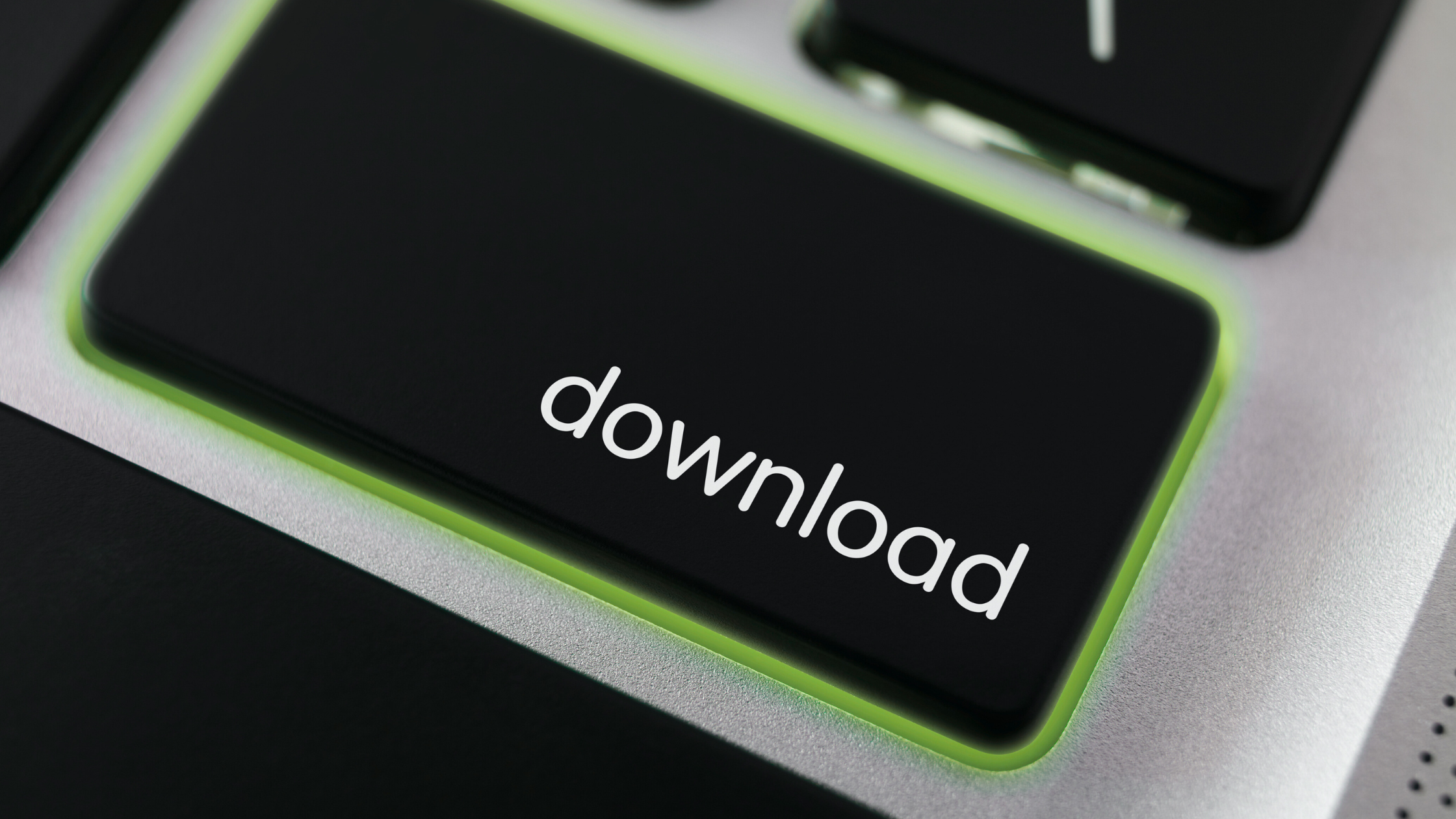 Close-up of illuminated keyboard download button with green backlight