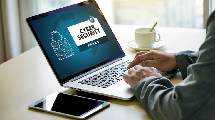 Person working on a laptop with cybersecurity protection interface, representing data privacy and online security.